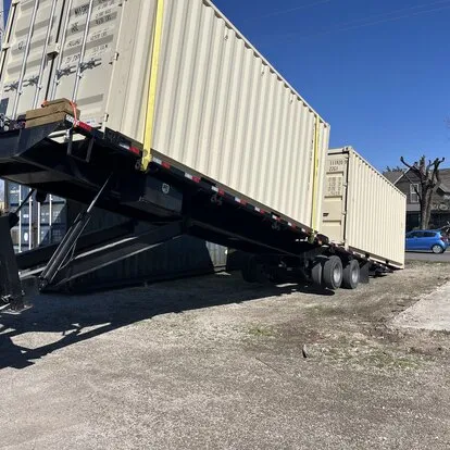 Shipping container being loaded or unloaded with a tilt trailer